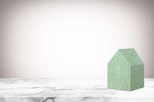 Concrete House Model on White Marble Table with Abstract White Gradient Texture Background. photo