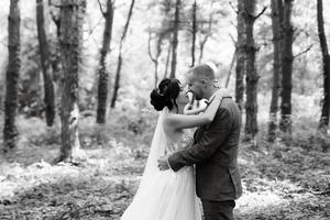 Boda caminar de el novia y novio en el caduco bosque en verano foto