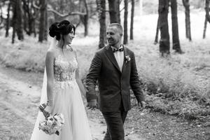 wedding walk of the bride and groom in the deciduous forest in summer photo