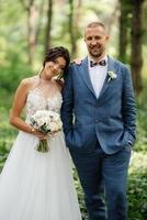 wedding walk of the bride and groom in the deciduous forest in summer photo