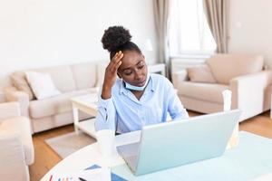 yo lata no creer yo atrapado un frío. frustrado africano americano mujer de negocios utilizando un pañuelo de papel a estornudar en mientras siendo sentado en el oficina. es gripe estación. enfermo joven negocio mujer a trabajo foto