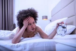 Woman lying in bed suffering from insomnia, Sleepless and desperate beautiful caucasian woman awake at night not able to sleep, feeling frustrated and worried suffering from insomnia in sleep disorder photo