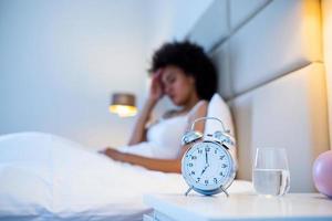 young beautiful woman at home bedroom lying in bed late at night trying to sleep suffering insomnia sleeping disorder or scared on nightmares looking sad worried and stressed photo