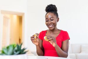 Young african american woman is reading a message from Fortune cookies, does the paper inside of the cookies tell you good things or photo