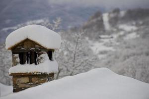 un Chimenea cubierto por nieve en invierno foto