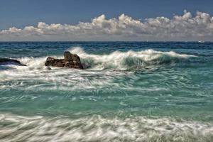 efecto de movimiento sobre las olas del mar en la orilla foto