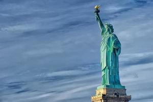 estatua de la libertad cerca vertical aislado en fondo azul nublado foto