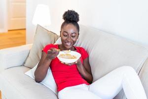 Portrait of an African American woman at home eating cereals for breakfast photo