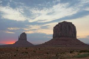 Monument Valley view at sunset with wonderfull cloudy sky and lights on mittens photo