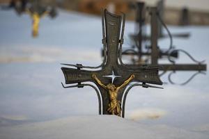 cemetery cross covered by snow photo