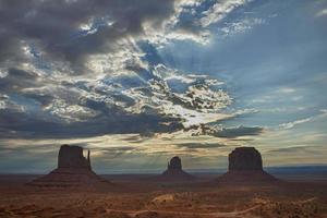 Monumento Valle Arizona ver a puesta de sol con maravilloso nublado cielo y luces en mitones foto
