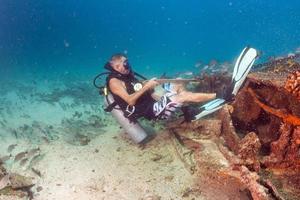 Diver holding boat anchor from underwater photo