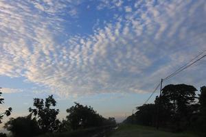 white clouds and sun against a background of blue sky photo