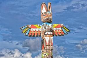 Totem wood pole in the gold cloudy background photo