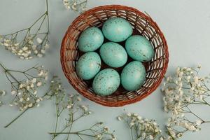 banner. Easter frame with eggs and feathers on a blue wooden background. Minimal concept. View from above. Card with copy space for text. photo