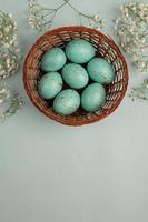 banner. Easter frame with eggs and feathers on a blue wooden background. Minimal concept. View from above. Card with copy space for text. photo