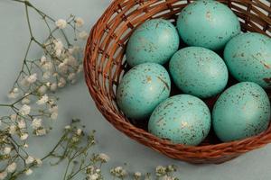 banner. Easter frame with eggs and feathers on a blue wooden background. Minimal concept. View from above. Card with copy space for text. photo