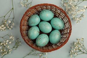 banner. Easter frame with eggs and feathers on a blue wooden background. Minimal concept. View from above. Card with copy space for text. photo