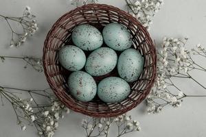 banner. Easter frame with eggs and feathers on a blue wooden background. Minimal concept. View from above. Card with copy space for text. photo