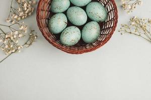 banner. Easter frame with eggs and feathers on a blue wooden background. Minimal concept. View from above. Card with copy space for text. photo