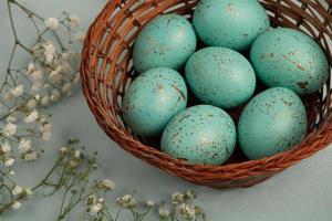 banner. Easter frame with eggs and feathers on a blue wooden background. Minimal concept. View from above. Card with copy space for text. photo