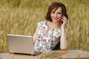 Beautiful woman or business woman talking on a cell phone outside. Outdoor portrait of a beautiful happy businesswoman talking on cell phone. photo