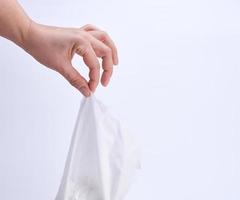 female hand holding a clean white paper napkin for face and body photo