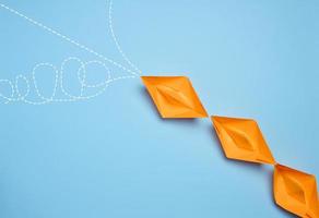 Paper boats on a blue background, representing the concept of competition in business, teamwork, and innovative approaches for achieving goals photo