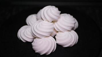 bonbons Meringue tourbillonne sur une noir Contexte video