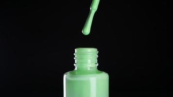 Green neon nail polish on black background video