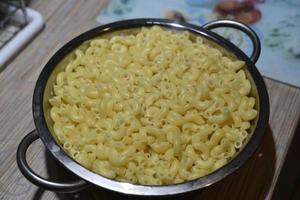 Boiled pasta in a colander. Yellow pasta close-up. Delicious breakfast. photo