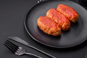 Meat cutlet or meatballs in tomato sauce with garlic, salt, spices and herbs photo