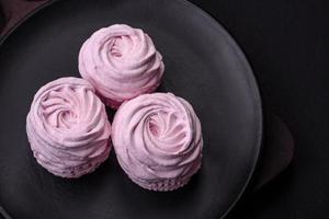 Delicious fresh natural airy marshmallows on a black ceramic plate photo