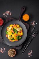 Delicious fresh vegetables steamed carrots, broccoli, cauliflower on a black plate photo