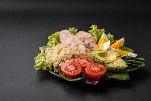 Delicious healthy lunch consisting of chicken, avocado, quinoa, eggs and tomatoes photo