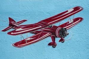 rojo biplano pintado en un pared foto