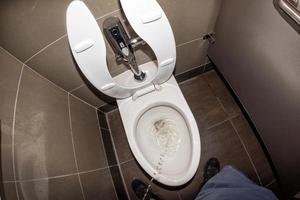 Man urinating in public restroom photo