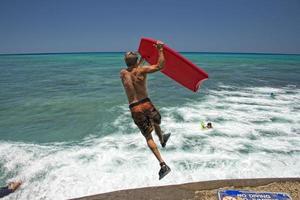 hombre saltando desde muelle con cuerpo navegar foto