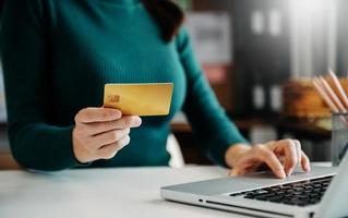 Woman using smart phone for mobile payments online shopping,omni channel,sitting on table,virtual icons graphics interface screen in morning light photo