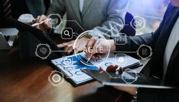 ágil desarrollo metodología concepto. negocio mano utilizando ordenador portátil y tableta con virtual pantalla ágil icono en moderno oficina digital tecnología concepto. foto