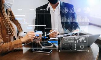 Businessman hand Project manager working and update tasks and Gantt chart scheduling virtual diagram.with smart phone, tablet and laptop in office. photo