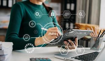 interfaz de programación de aplicaciones api, mujer que usa computadora portátil, tableta y teléfono inteligente con herramienta de desarrollo de software de icono de pantalla virtual api, tecnología y concepto de red. foto