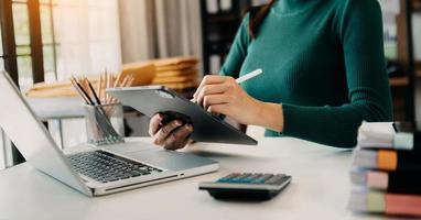 Businessman hand using smart phone laptop and tablet with social network diagram on desk as concept in morning light. photo