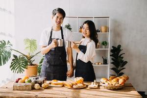 Image of newlywed couple cooking at home. Asia young couple cooking together with Bread and fruit in cozy kitchen in home photo