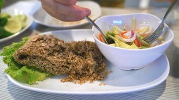 person eating crispy catfish with Mango salad,Thai food,slow motion movement video