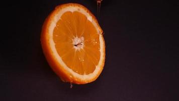 Flüssigkeit Honig fließt Nieder langsam von ein Orange Ring auf ein schwarz Hintergrund video