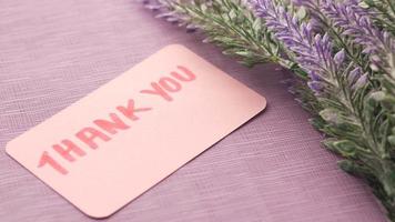 Thank you message on sticky note and lavender flower on table video