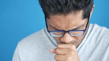 Sick man got flu allergy sneezing and blowing nose against blue background video