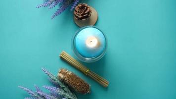 Natural candle in a glass jar and dried flowers on blue video