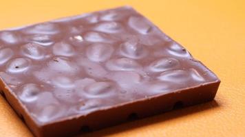 Dark chocolate on a plate on table close up . video